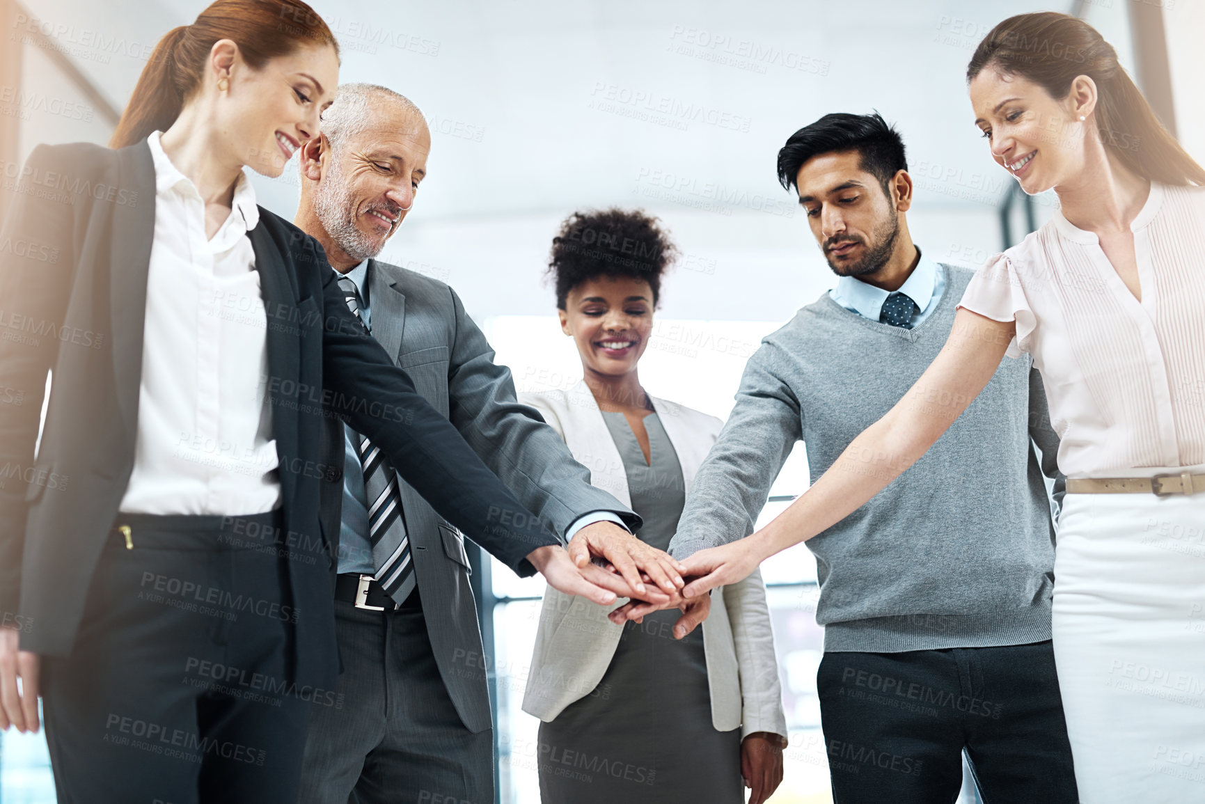 Buy stock photo Shot of a diverse team of colleagues joining their hands together in solidarity