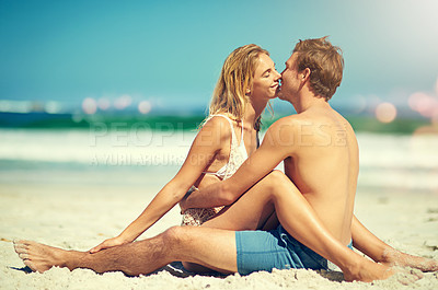 Buy stock photo Full length shot of an affectionate young couple sitting face to face on the beach