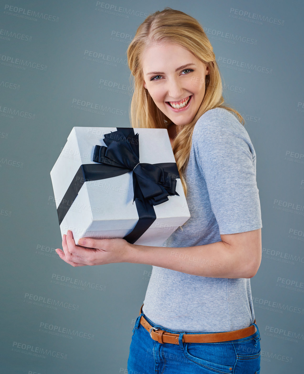 Buy stock photo Happy woman, portrait and gift with ribbon box for birthday, present or surprise in studio on a gray background. Excited, female person or model with package, parcel or wrapped bundle for anniversary