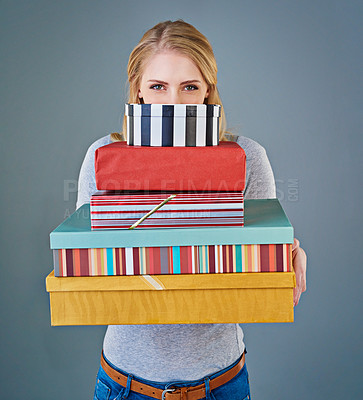 Buy stock photo Cropped studio shot of a young woman holding a stack of presents