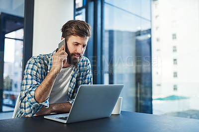 Buy stock photo Cropped shot of a young designer talking on a cellphone in a modern office