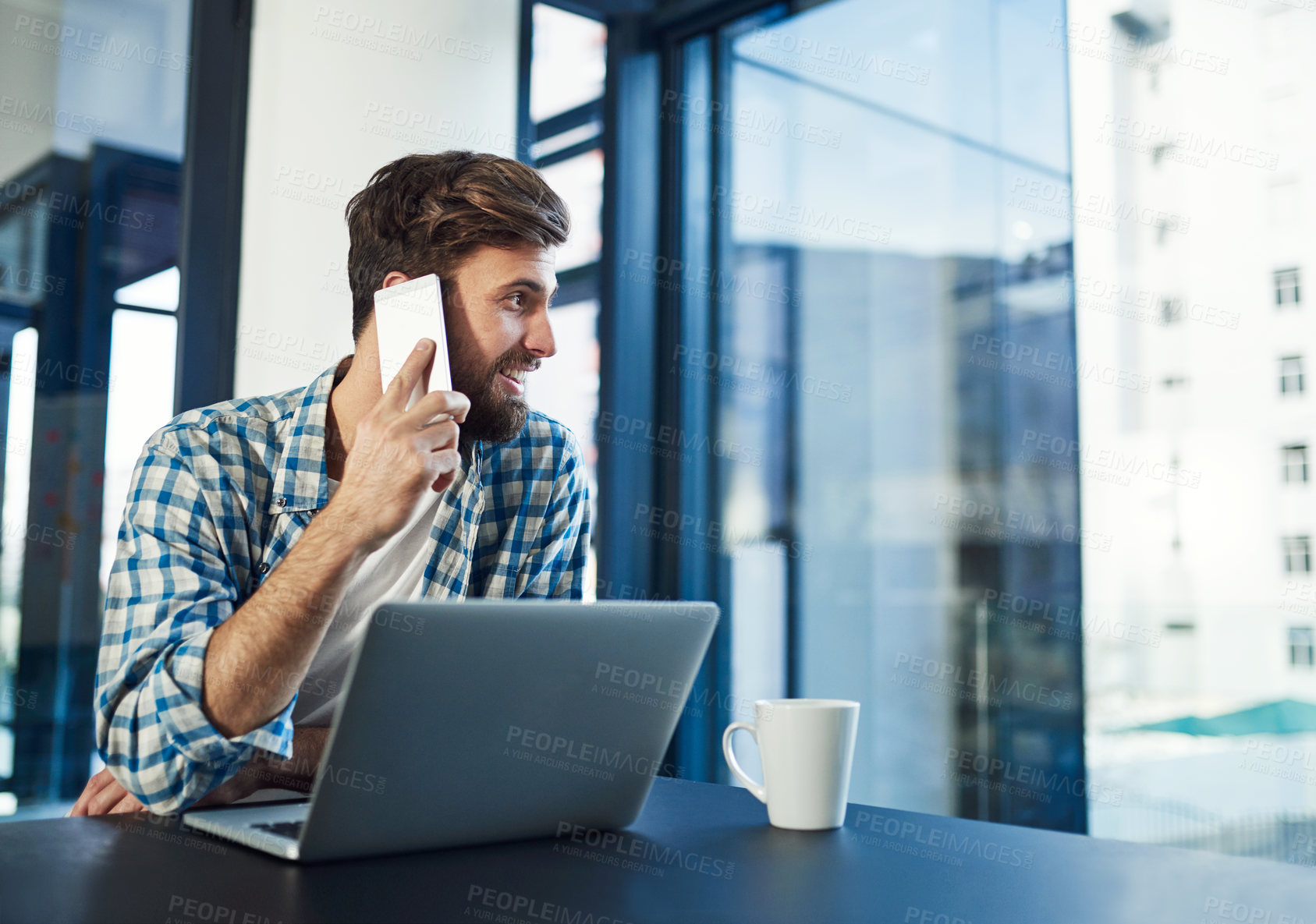 Buy stock photo Cropped shot of a young designer talking on a cellphone in a modern office