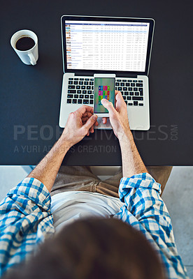 Buy stock photo High angle shot of a young designer using a cellphone in a modern office