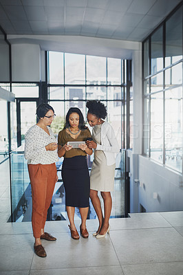 Buy stock photo Full length shot of three businesswomen looking at a tablet in the office