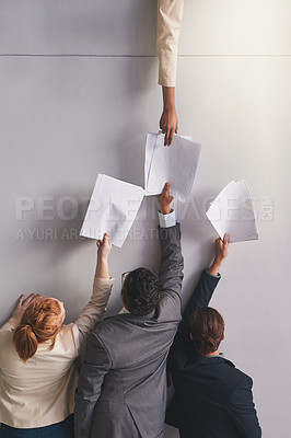 Buy stock photo Cropped shot of businesspeople handing documents to a colleague in an office
