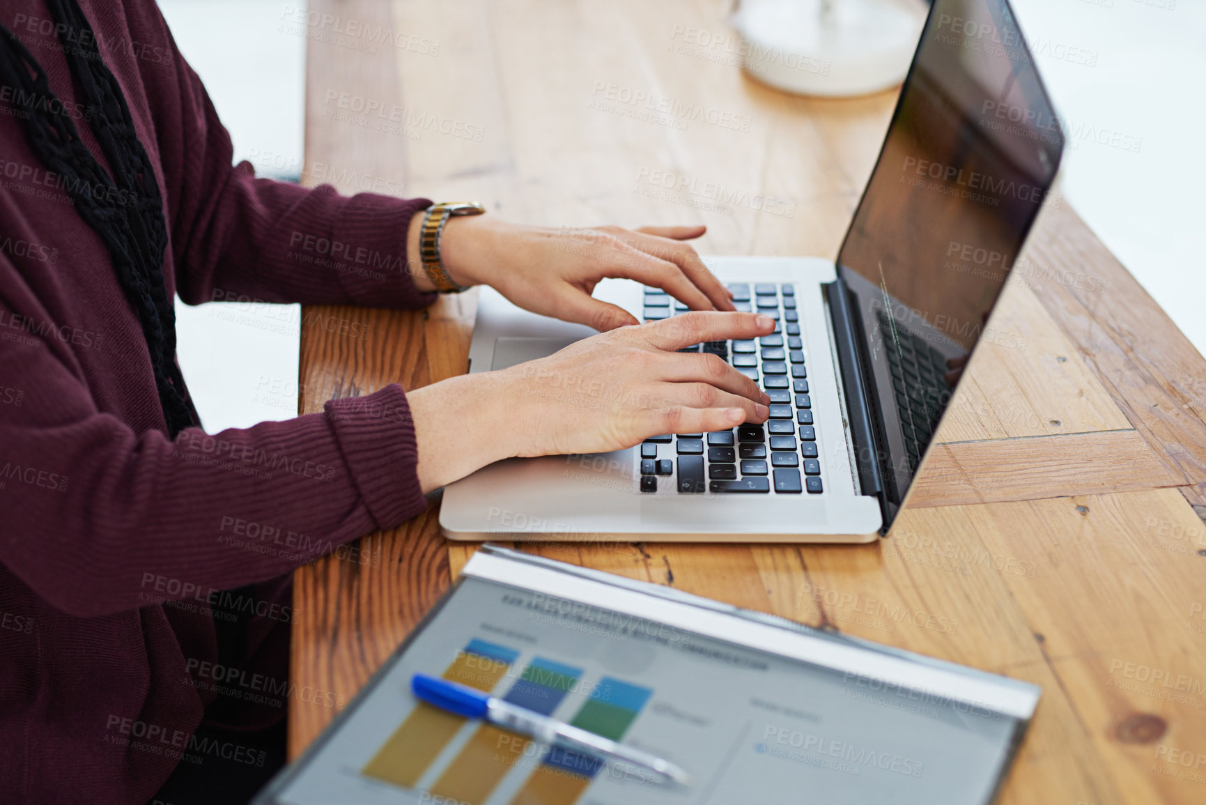 Buy stock photo Cropped shot of an unidentifiable woman using her laptop in the office