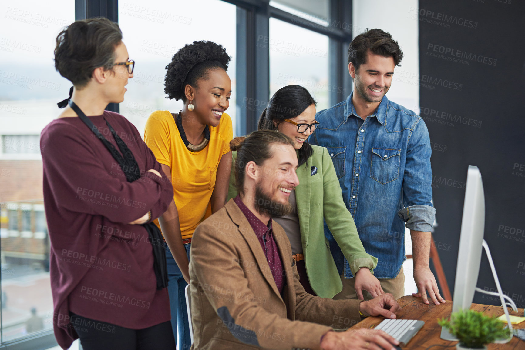 Buy stock photo Cropped shot of a group of creative businesspeople looking at something on a computer