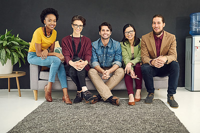 Buy stock photo Portrait of a group of young creatives sitting together on a couch in an office