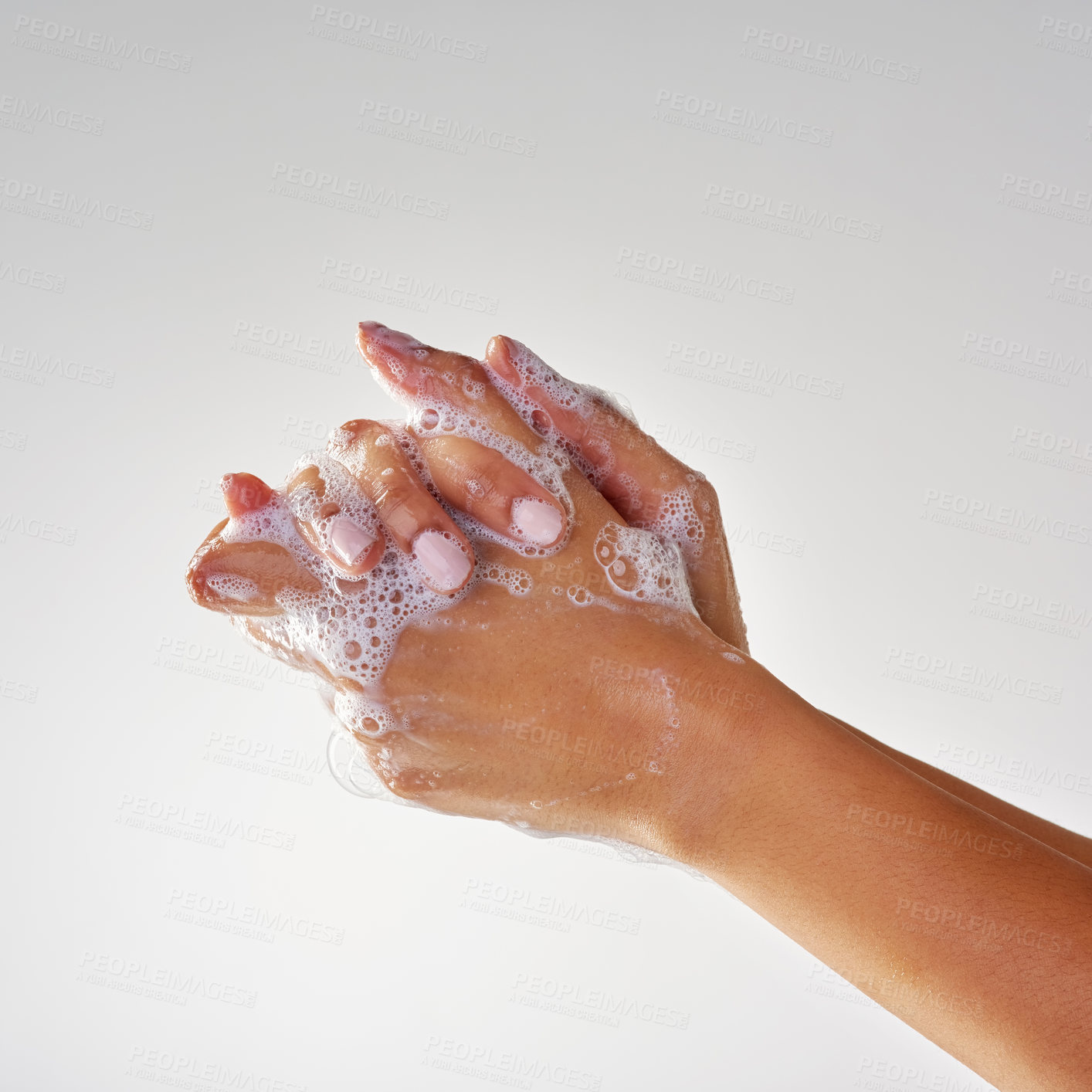 Buy stock photo Cropped shot of hands being washed with soap against a grey background