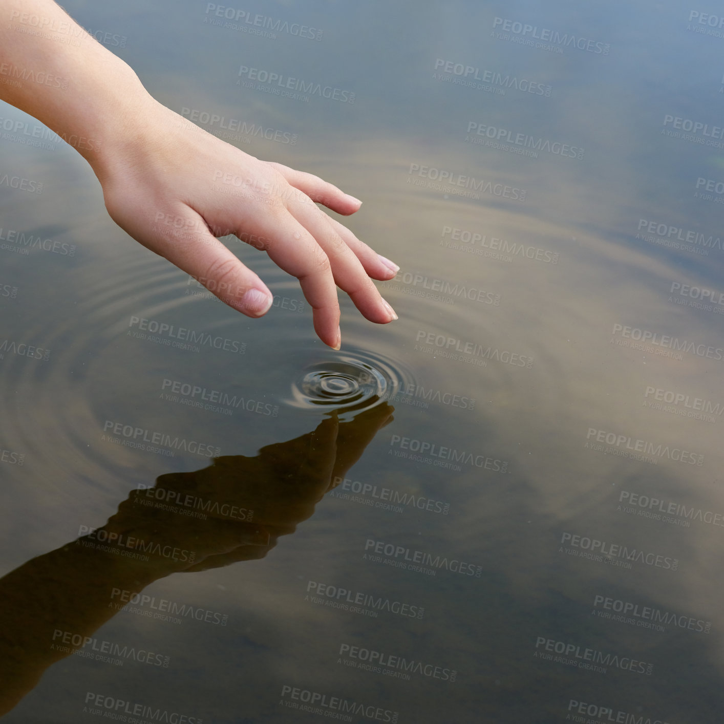 Buy stock photo Cropped shot of a finger touching water to form ripples