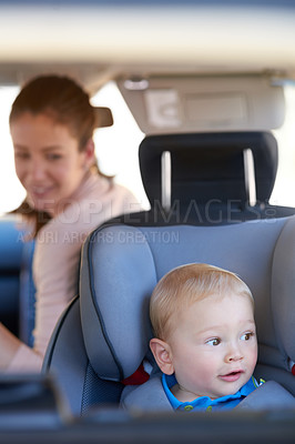Buy stock photo Cropped shot of a mother sitting in a car with her baby boy in a car seat