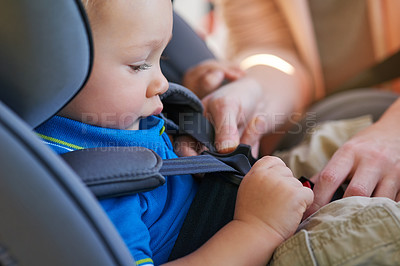 Buy stock photo Cropped shot of a mother fastening her baby boy safely in a car seat