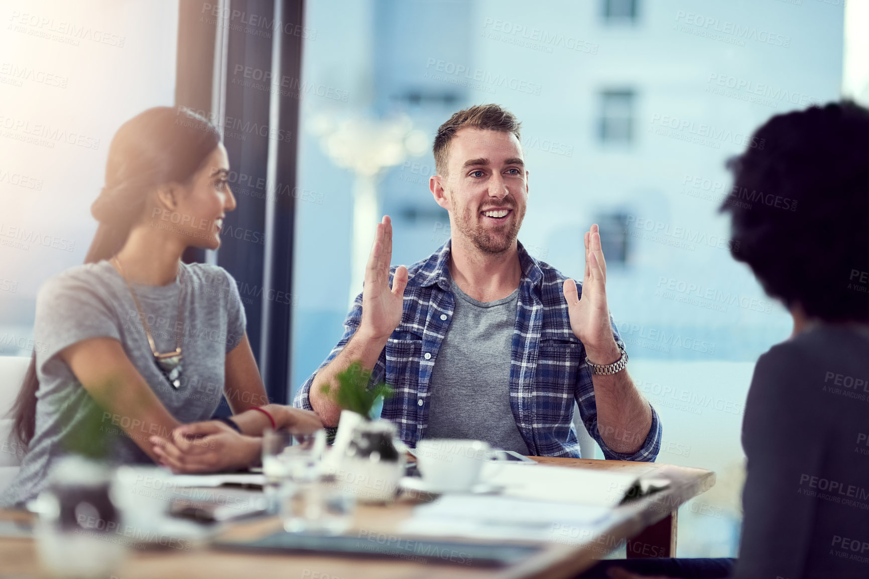 Buy stock photo Man, conversation and explain in modern office for startup with collaboration, teamwork and meeting. Male entrepreneur, talking with coworkers and gesture at creative agency for job and lens flare