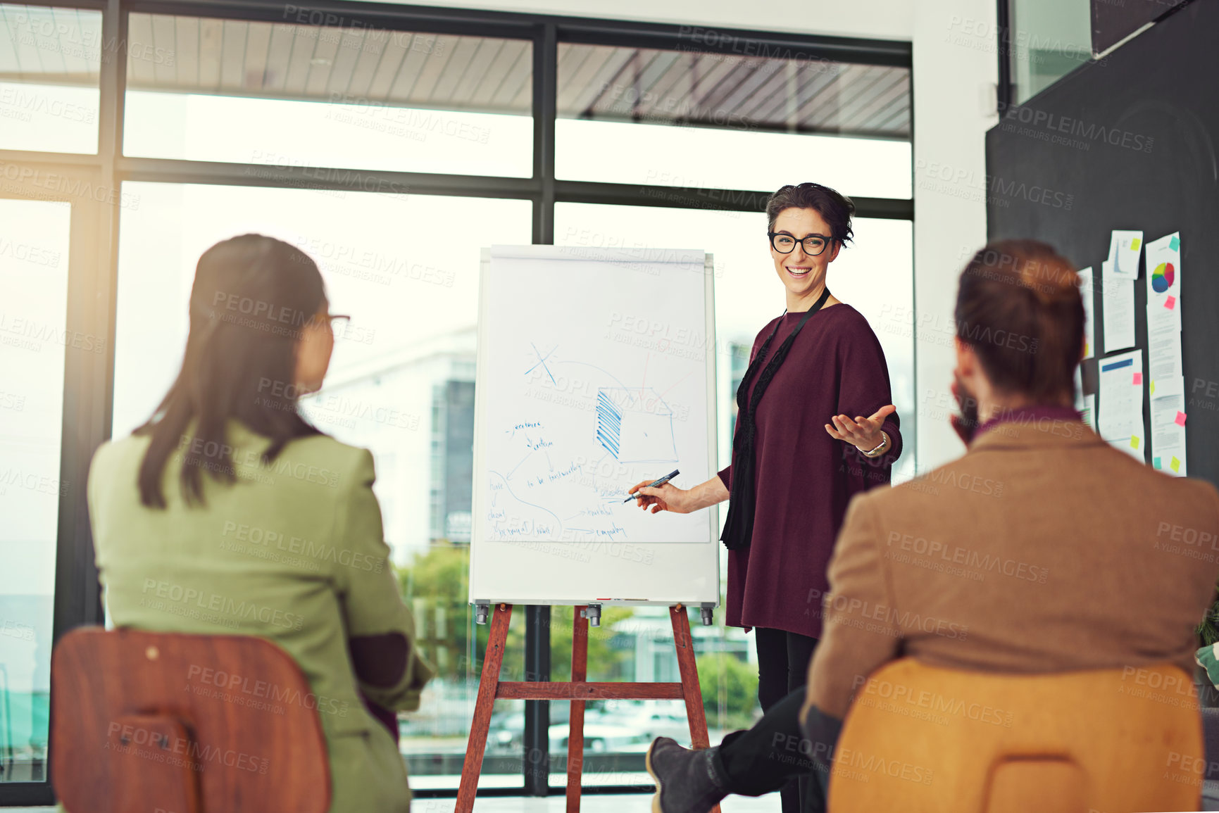 Buy stock photo Cropped shot of a young creative giving a presentation to her colleagues in an office