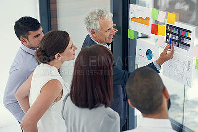Buy stock photo Cropped shot of a group of businesspeople looking at graphs together