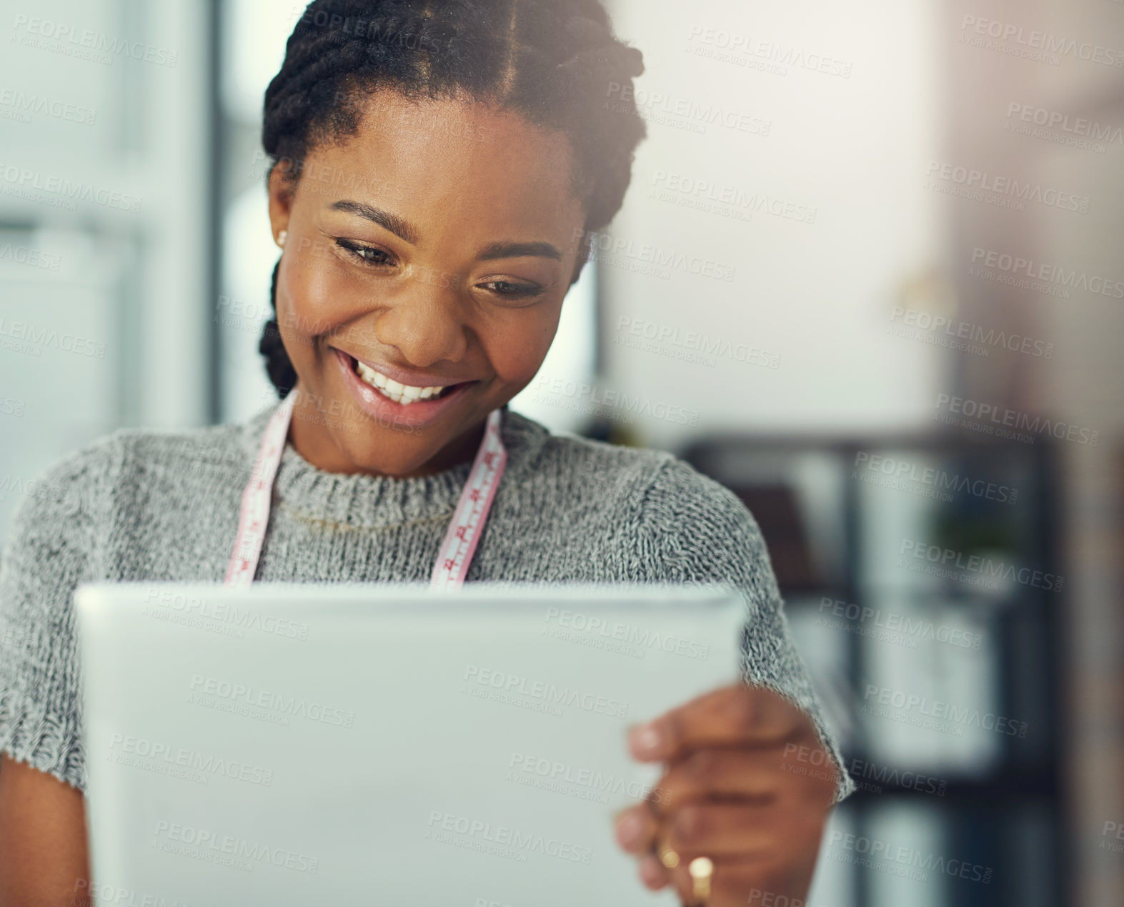 Buy stock photo Shot of a fashion designer looking at something on her tablet