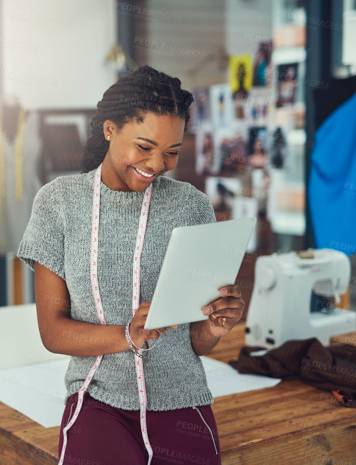 Buy stock photo Shot of a fashion designer looking at something on her tablet