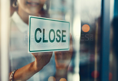 Buy stock photo Closeup shot of a young business owner hanging up a close sign on the door of her shop