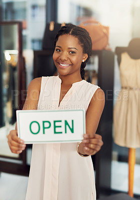 Buy stock photo Portrait of a young business owner holding an open sign in her shop
