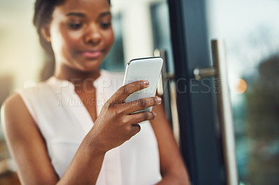 Buy stock photo Cropped shot of a young business owner using a cellphone in her shop