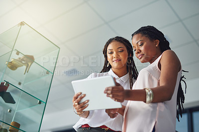 Buy stock photo Cropped shot of young business partners working on a digital tablet together