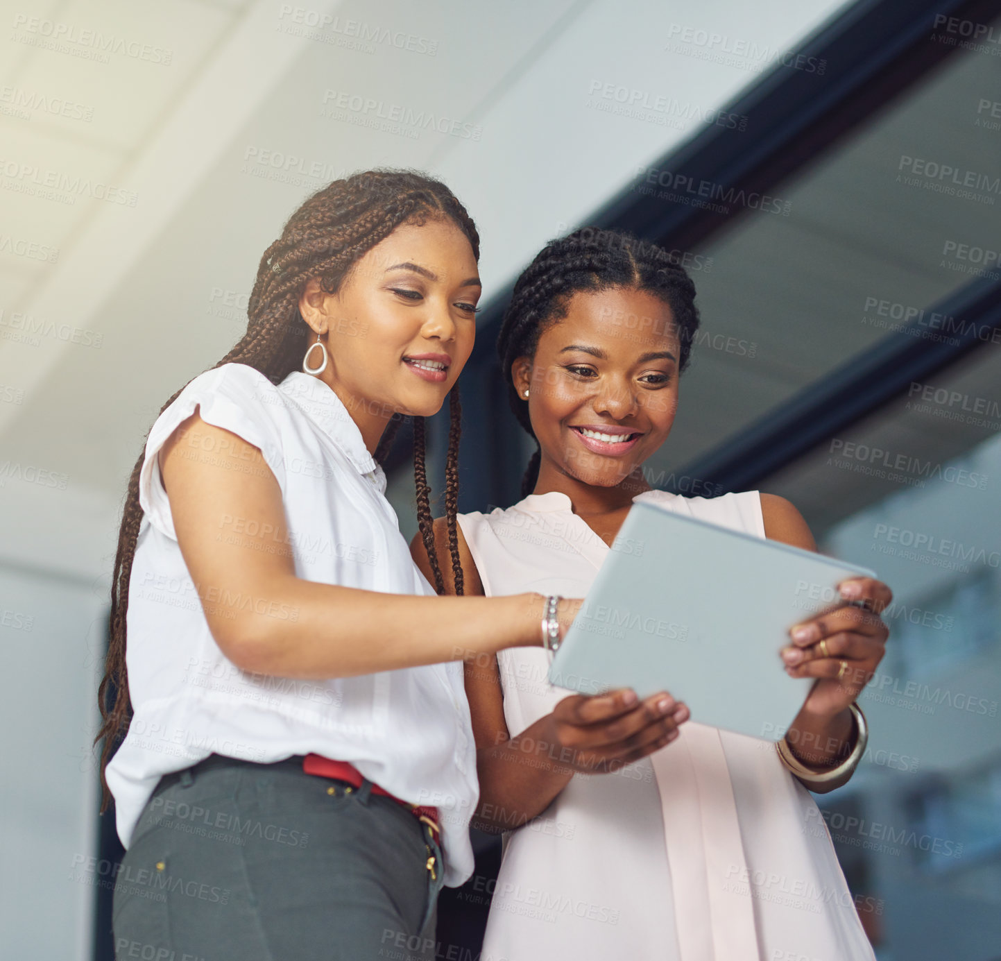 Buy stock photo Cropped shot of young business partners working on a digital tablet together