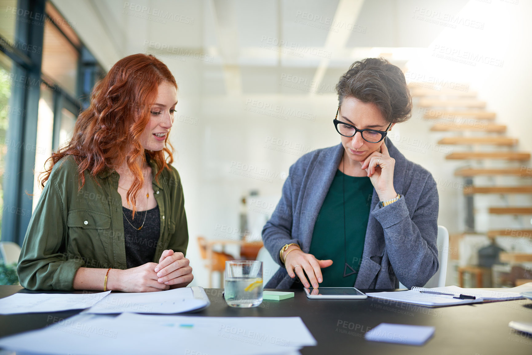 Buy stock photo Tablet, teamwork or business women in startup for news, conversation or discussion in office together. Paperwork, meeting or people planning strategy, feedback data or info online in collaboration