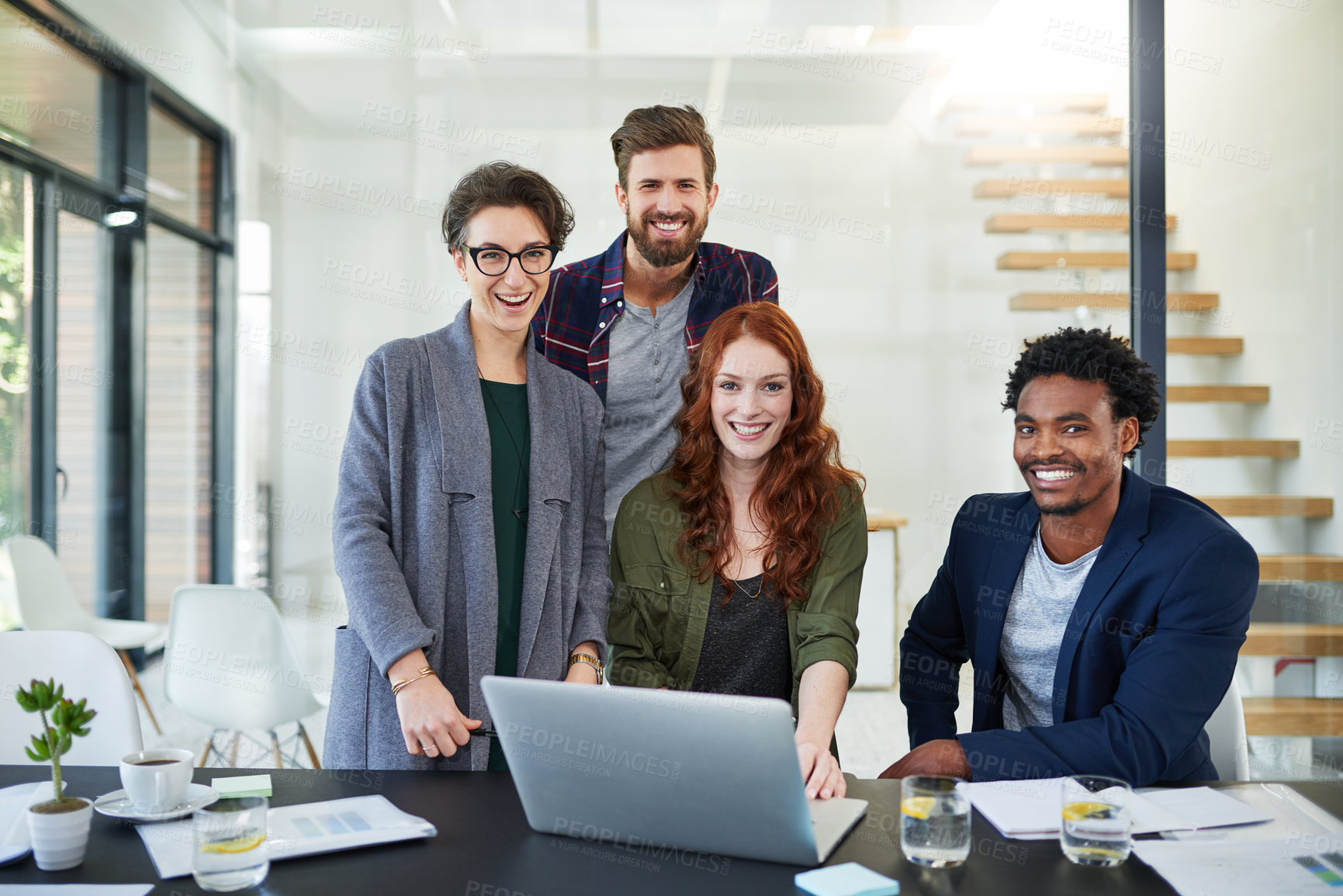 Buy stock photo Portrait of a group of young creatives working together on a laptop in a modern office