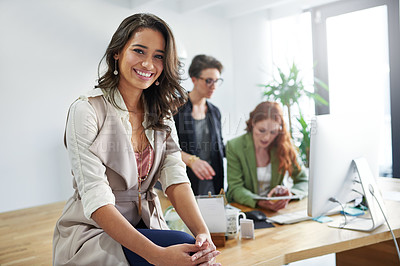Buy stock photo Portrait of a young creative sitting in an office with colleagues in the background