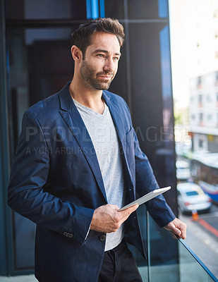 Buy stock photo Cropped shot of a businessman using his tablet while standing on a balcony