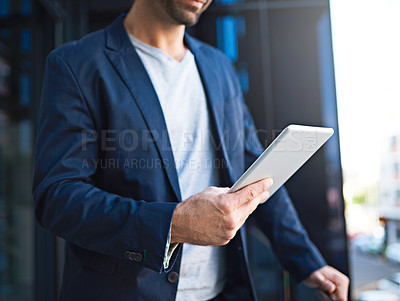 Buy stock photo Cropped shot of an unrecognizable businessman using his tablet while standing on a balcony