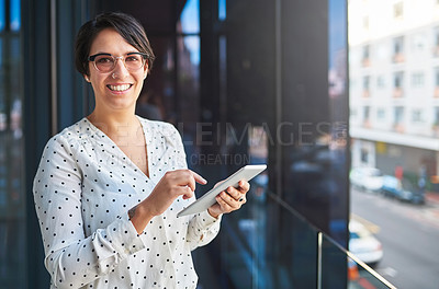 Buy stock photo Cropped shot of a young businesswoman using her tablet while standing on a balcony