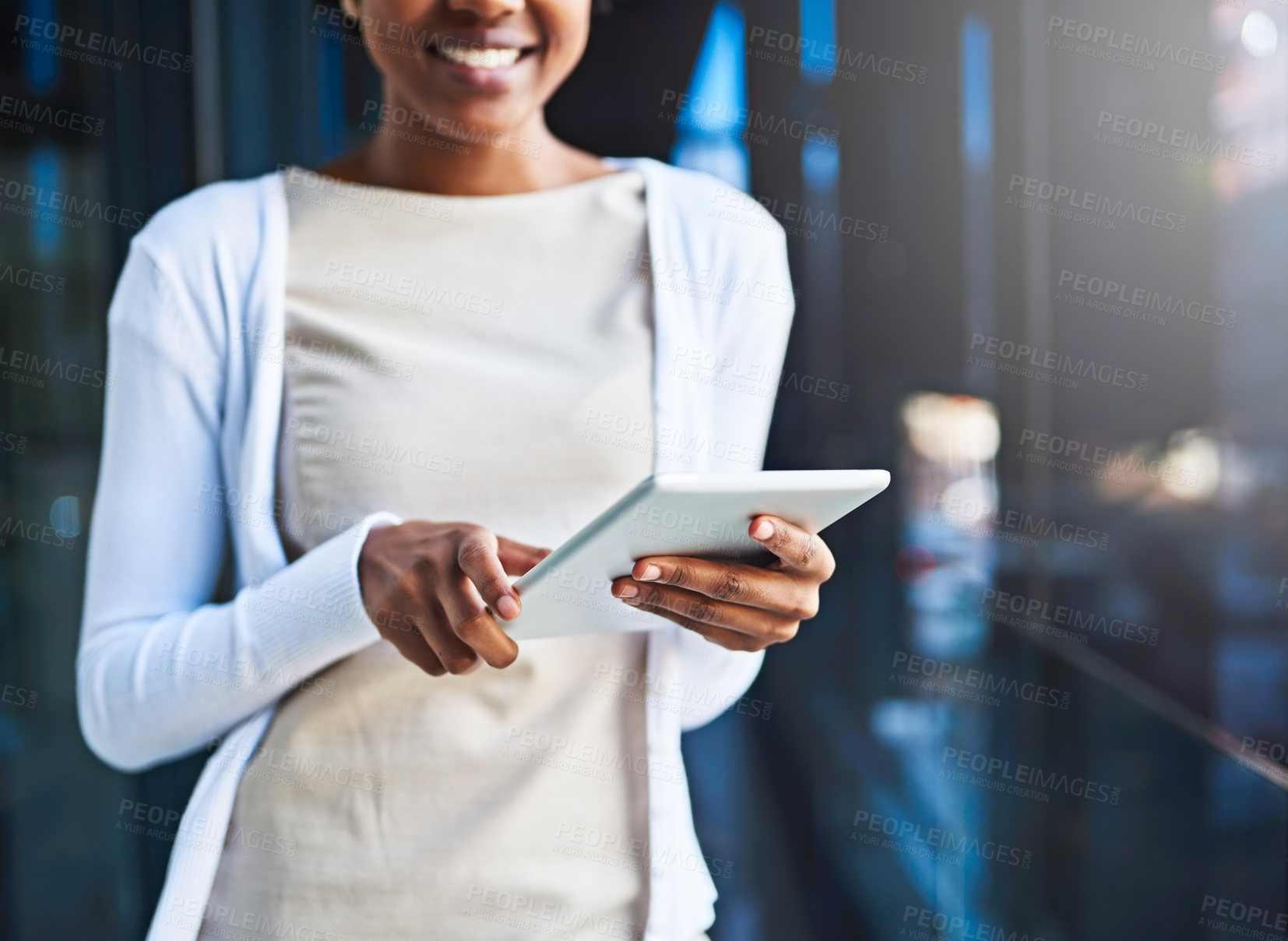 Buy stock photo Cropped shot of an unrecognizable young businesswoman using her tablet while standing on a balcony