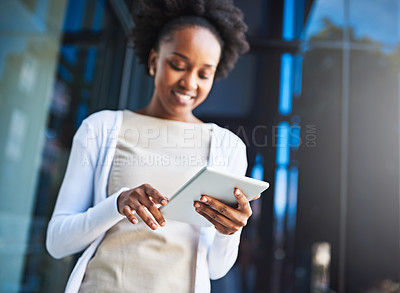 Buy stock photo Cropped shot of a young businesswoman using her tablet while standing on a balcony