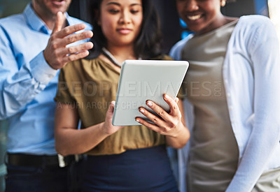 Buy stock photo Cropped shot of a group of businesspeople using a digital tablet while standing on a balcony
