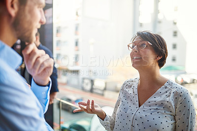 Buy stock photo Cropped shot of two businesspeople having a conversation while standing on a balcony