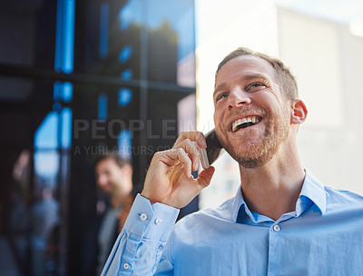 Buy stock photo Cropped shot of a businessman answering his cellphone while standing on a balcony