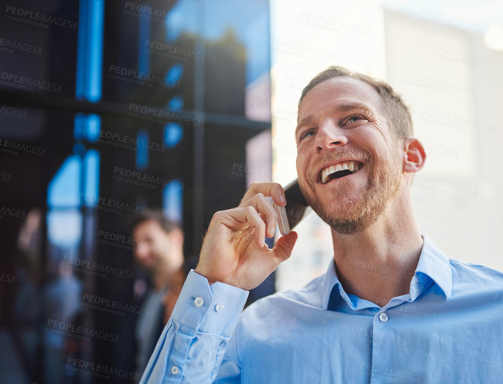 Buy stock photo Cropped shot of a businessman answering his cellphone while standing on a balcony