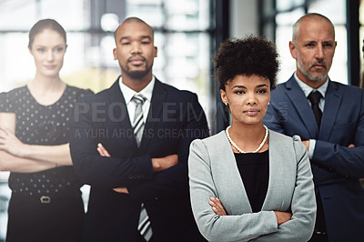 Buy stock photo Shot of a focused businesswoman standing in front of her team at work
