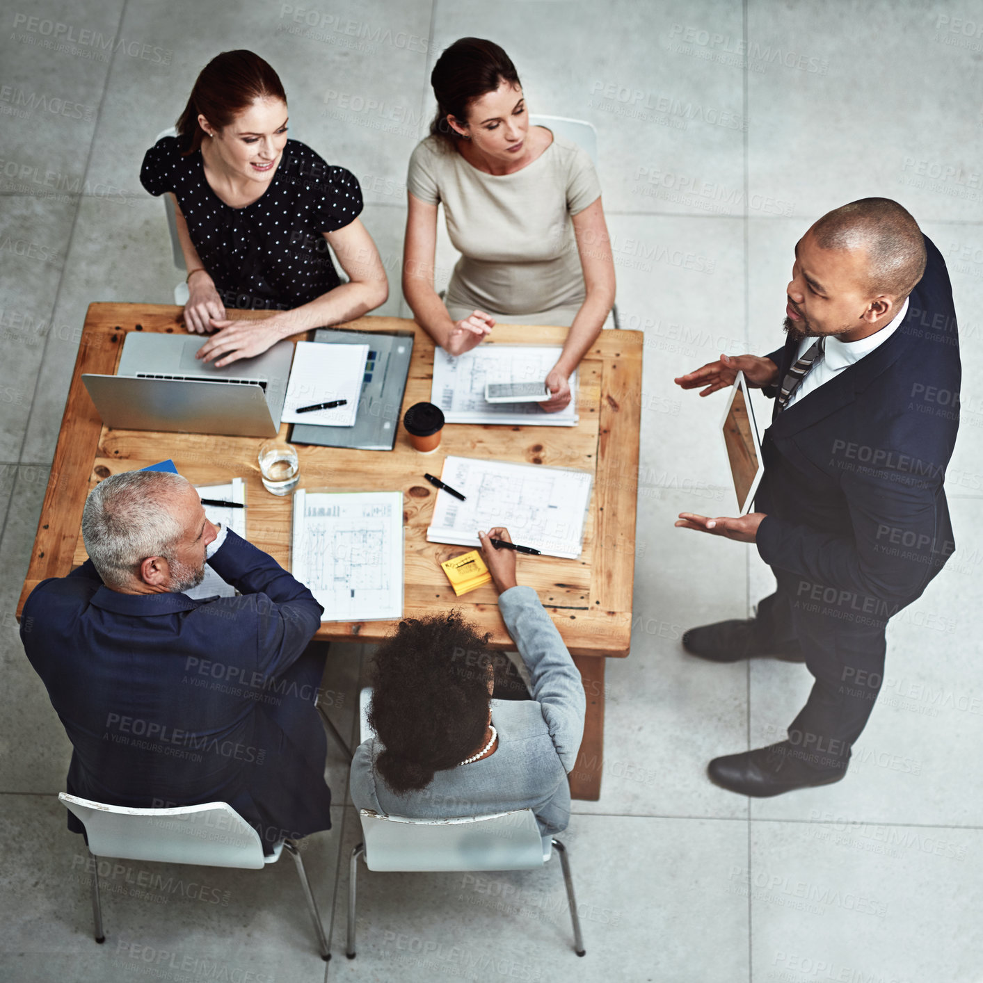 Buy stock photo Shot of a businessman showing his colleagues something on a digital tablet during a meeting at work