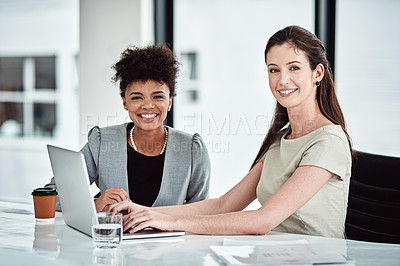 Buy stock photo Portrait of two businesswomen using a laptop together in an office