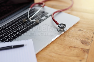 Buy stock photo Closeup shot of a laptop, stethoscope and doctor's notebook on a table