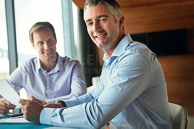 Buy stock photo Shot of two businessmen discussing paperwork while sitting in an office