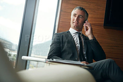 Buy stock photo Cropped shot of a businessman answering a phonecall while sitting in his office