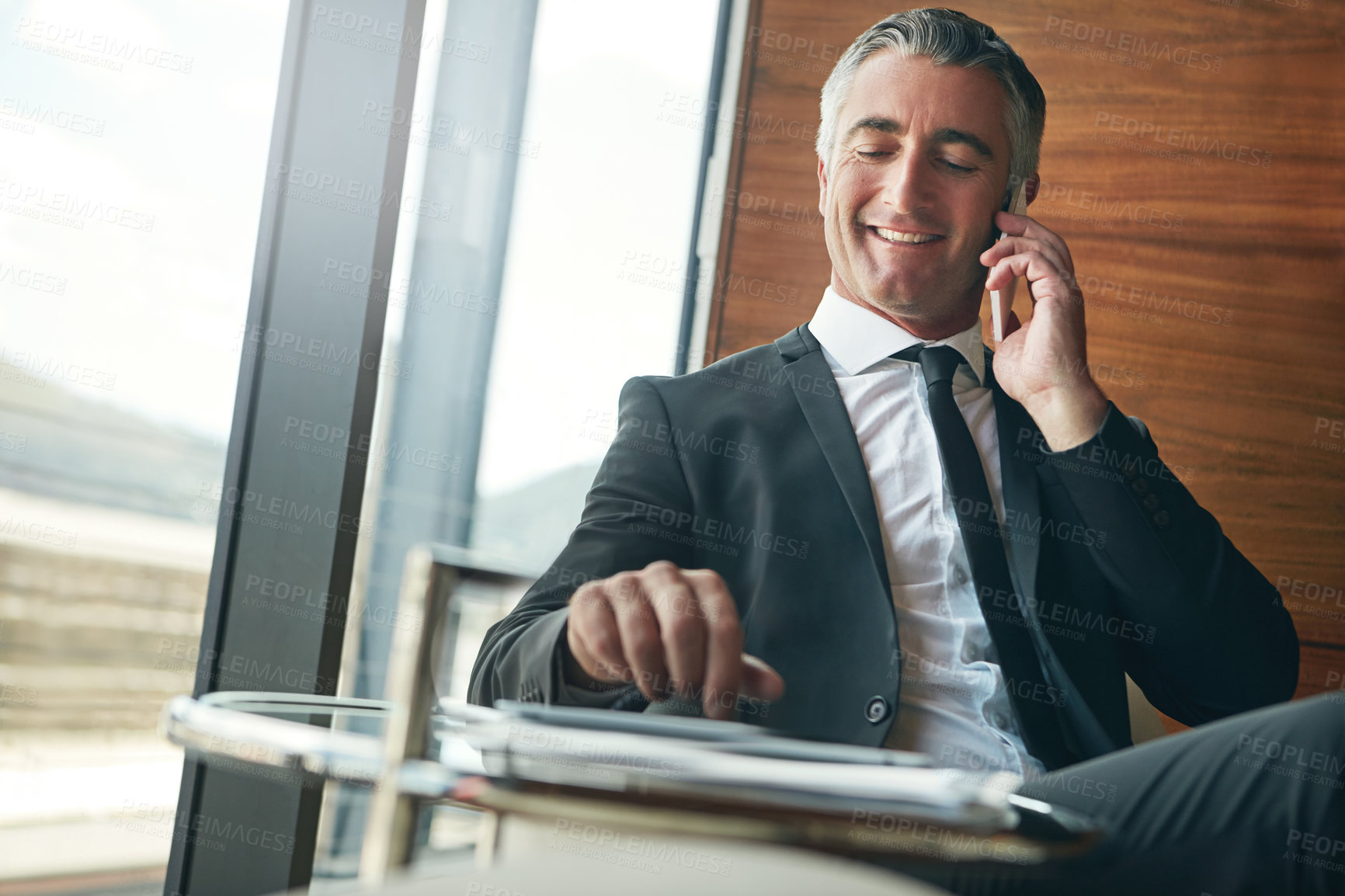 Buy stock photo Cropped shot of a businessman answering a phonecall while sitting in his office