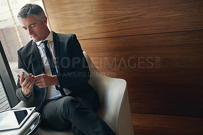 Buy stock photo Shot of a mature businessman using his phone at work