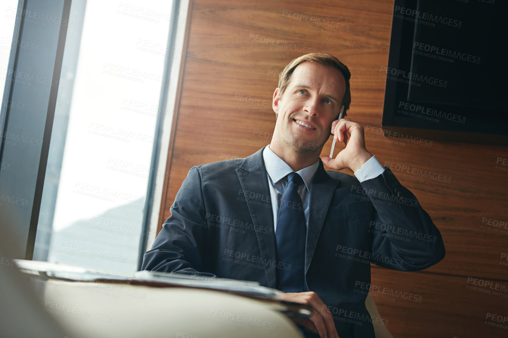 Buy stock photo Cropped shot of a businessman answering a phonecall while sitting in his office