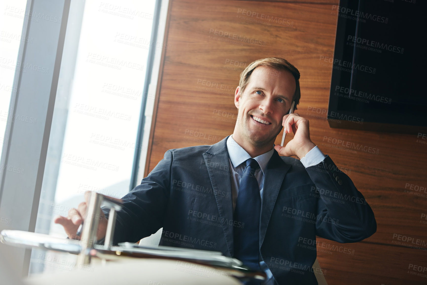 Buy stock photo Cropped shot of a businessman answering a phonecall while sitting in his office