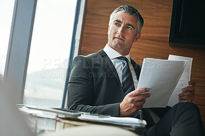 Buy stock photo Shot of a mature businessman going through paperwork at work
