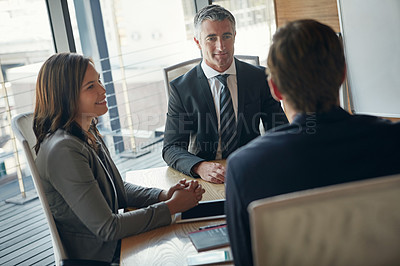 Buy stock photo Portrait of a mature businessman sitting in an office with colleagues